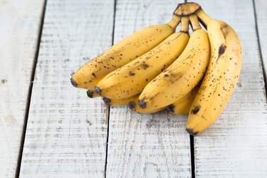 Raw Organic Bunch of Bananas Ready to Eat on wooden table