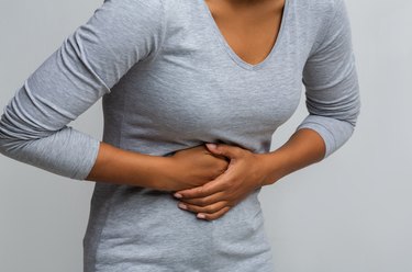 Woman suffering from gastritis, touching her tummy