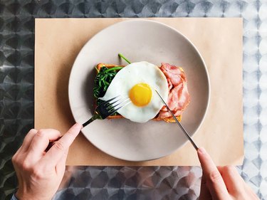 吃早餐与比利时华夫饼干、培根、菠菜和煎蛋、个人透视图