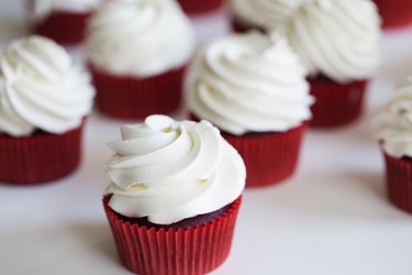 cupcakes topped with swirl of sweet vanilla frosting. Red velvet cupcakes
