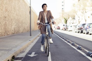 Woman with bike on bicycle lane in the city