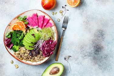 Vegan, detox Buddha bowl with quinoa, micro greens, avocado, blood orange, broccoli, watermelon radish, alfalfa seed sprouts. Top view, flat lay, copy space
