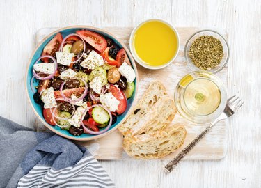 Greek salad with olive oil, bread, spices and white wine