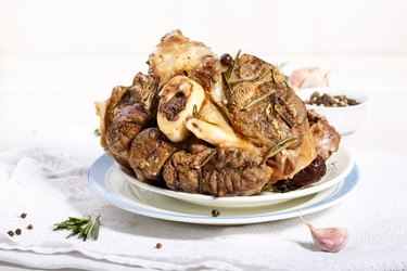 beef shanks with beef bone marrow braised with garlic rosemary and dried fruits. Rustic style.