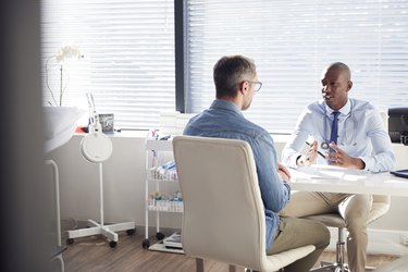 Mature Male Patient In Consultation With Doctor In Office