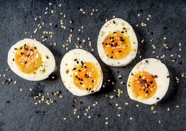 Halved hard-boiled eggs on black background as part of a keto diet breakfast