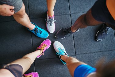 Diverse people wearing running shoes standing in a gym