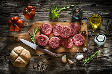 Raw hamburger patties with ingredients shot from above