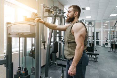 Man resting during HIIT workout with weight vest.