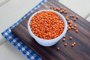 High Angle View Of Red Lentils In Container On Cutting Board