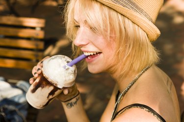 Young woman drinking gluten frappe with a straw