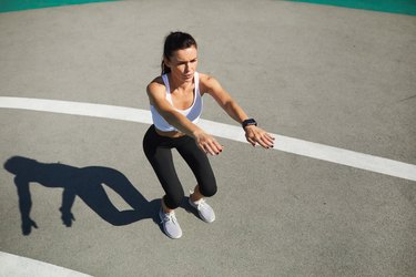 Woman doing squat at stadium