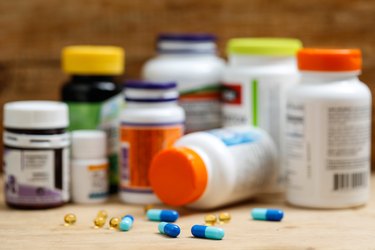 Medicine bottles and tablets on wooden desk