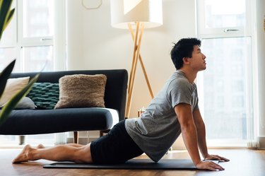 Man doing upward facing dog yoga pose at home