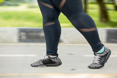 Woman's legs in black leggings on road