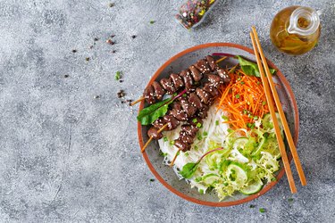 Chicken hearts in spicy sauce, rice noodles and vegetable salad. Healthy food. Top view