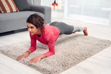 Woman doing a forearm plank exercise as part of a Pilates for beginners workout