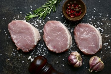 Slices of raw organic pork meat with ingredient for making