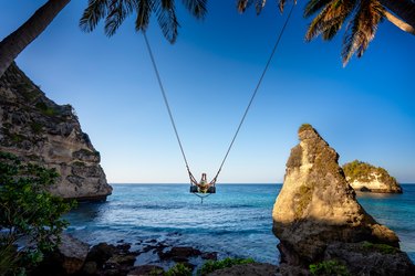 Young woman swinging at Nusa Penida, Indonesia.