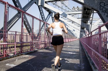 年轻活跃的女子在威廉斯堡桥上跑步