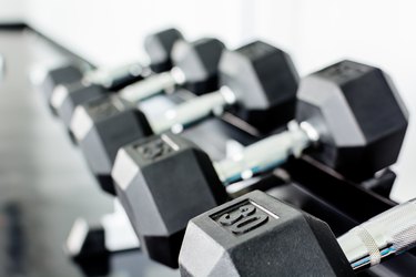 rows of dumbbells on a rack in a gym