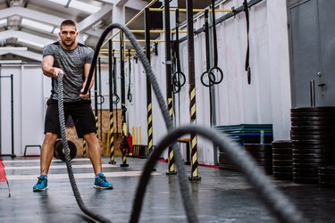 Man Doing Battle Rope Workout in the Gym