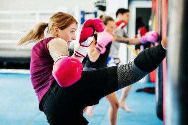 Women in a cardio kickboxing class at a gym for health benefits