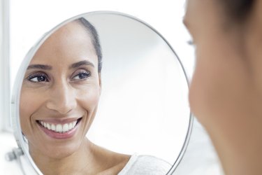 Woman looking in mirror, smiling
