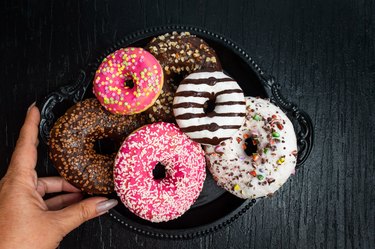 Woman serving decorated chocolate donuts