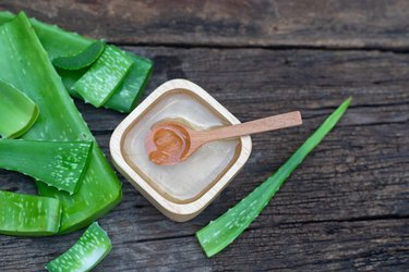 Fresh aloe vera stem and gel on a wooden table, as a natural remedy for canker sores