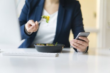 Counting calories Businesswoman eating lunch in office