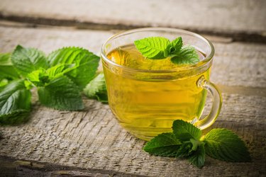 cups of tea with mint on wooden