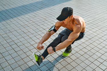man wearing leggings hat and arm band doing squat on one leg