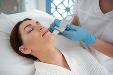 Lady enjoying of suprasonic procedure of face