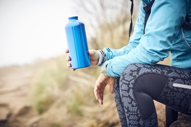 Midsection of female traveler holding water bottle