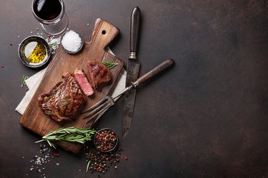 Grilled ribeye beef steak with red wine, herbs and spices