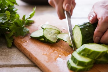 Woman cuts cucumber for diabetes on sliced parts