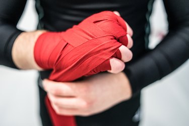MMA boxing fighter putting hand wraps on hands