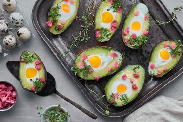Keto diet dish: Avocado boats with ham cubes, quail eggs and cress sprout