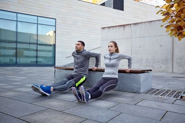 couple doing triceps dip exercise outdoors