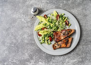Salmon with fresh salad on gray table