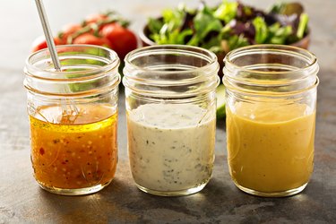 Three types of homemade low-carb salad dressings in glass jars