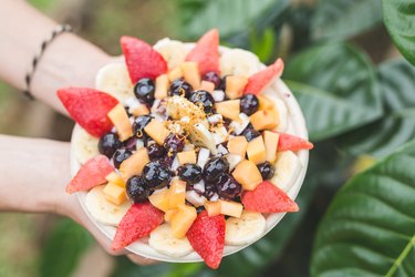 Food combining breakfast smoothie bowl topped with fresh fruit
