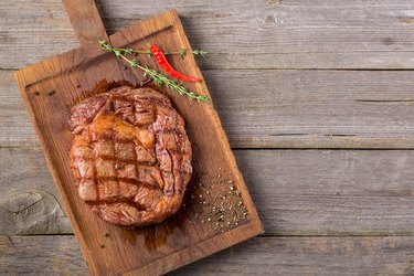 Rib eye steak on wooden board with copyspace