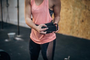 Woman putting on belt for dead lift training