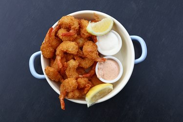 Portion of breaded shrimps with dipping sauces