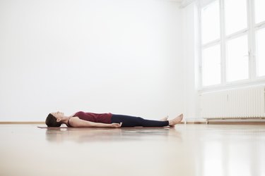 Woman in exercise studio lying on back on floor