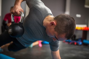 Man lifting kettlebell during ab workout