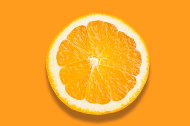 Close-Up Of Orange Slice Over Orange Background