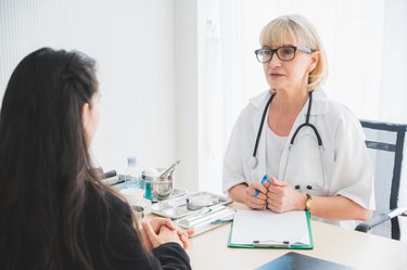 Senior female doctor meet the patient discussing and making notes about symptom problem. Health care and client service in medicine concept.